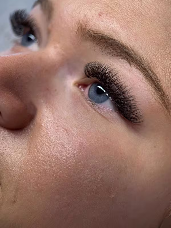 Makroaufnahme einer dichten Volumen Wimpernverlängerung mit gleichmäßig gefächerten Extensions.