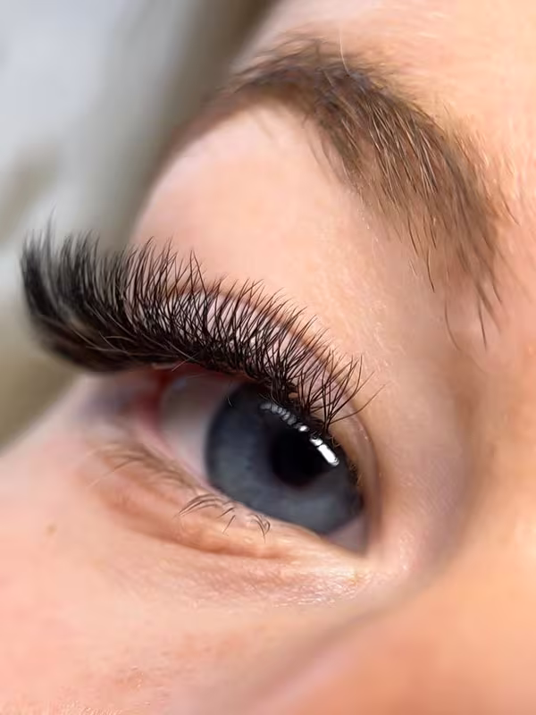 Detailaufnahme einer Volumen Wimpernverlängerung mit dichten und gleichmäßig gefächerten Wimpern.